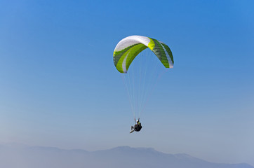 Fototapeta na wymiar Sepia paraglide silhouette over Alps peaks