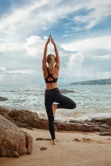 Foto op Plexiglas women doing yoga with the ocean behind © chesterF