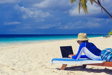 Obraz na płótnie Canvas man with laptop on beach vacation