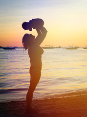 mother and daughter having fun at sunset beach