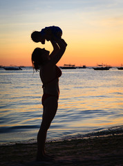 Fototapeta premium mother and daughter having fun at sunset beach