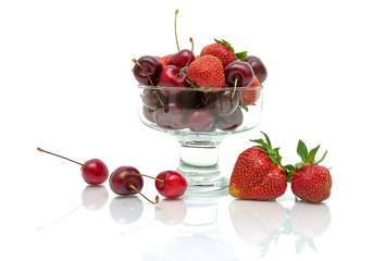 juicy cherries and strawberries in a glass bowl isolated on whi