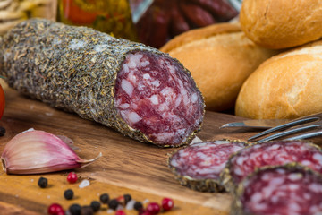 traditional salami with herbs on wooden board