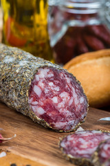 traditional salami with herbs on wooden board and bread