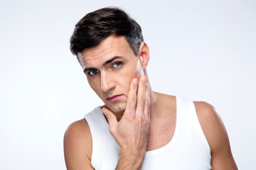 Young man after shaving over gray background