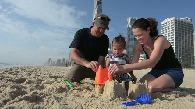 Family builds sand castle 01