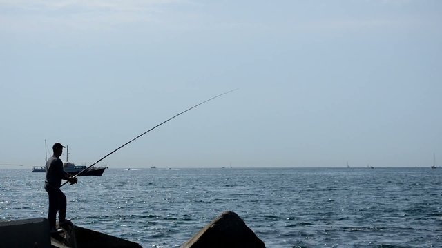 A Fisherman Throws A Fishing Rod