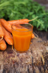 Carrot juice on wooden background