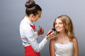 Make-up artist applying powder with a brush on model's