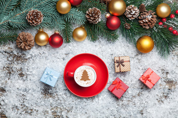 Cappuccino with christmas tree shape and gift box on artificial