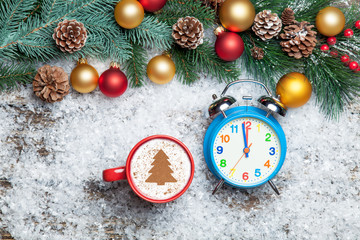 Cappuccino with christmas tree shape and clock on artificial sno