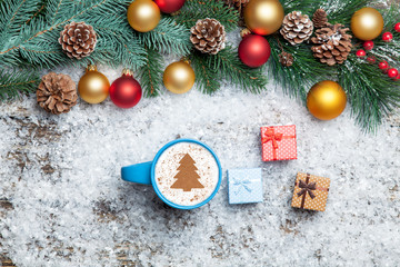 Cappuccino with christmas tree shape and gifts on artificial sno
