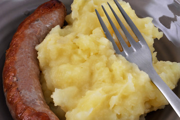 Gros plan sur une assiette avec saucisse et purée