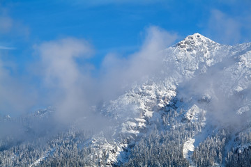 mountain peak in winter clouds