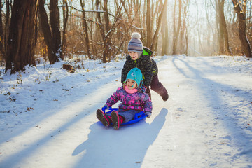 Two children with sled in a forest