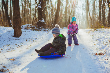 Two children with sled in a forest