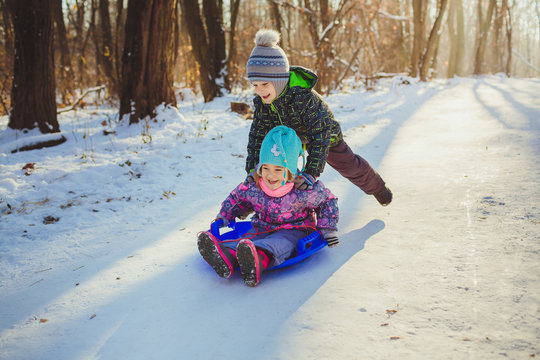 Two children with sled in a forest