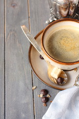 Cup of coffee, sugar cubes and chocolate drops