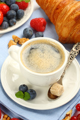 Breakfast with cup of coffee, croissants and berries