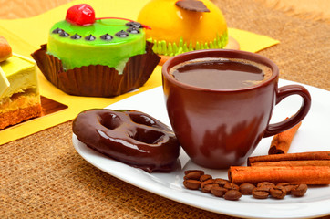 Different cakes, cup of coffee, cinnamon sticks and chocolate co