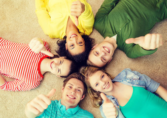 group of smiling people lying down on floor
