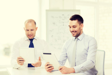 Fototapeta premium two smiling businessmen with tablet pc in office