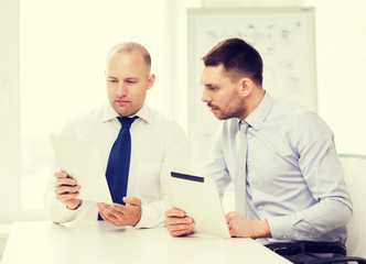 Fototapeta premium two serious businessmen with tablet pc in office