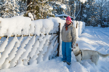 The woman with a dog on walk in a winter wood