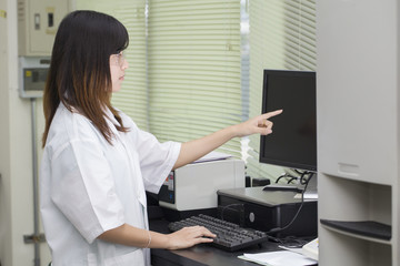 Female Scientist Looking On Computer Screen In Lab