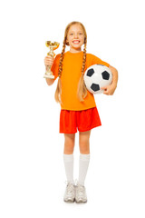 Little blond girl holding soccer ball and prize