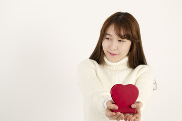 Smiling young asian woman with red heart shape