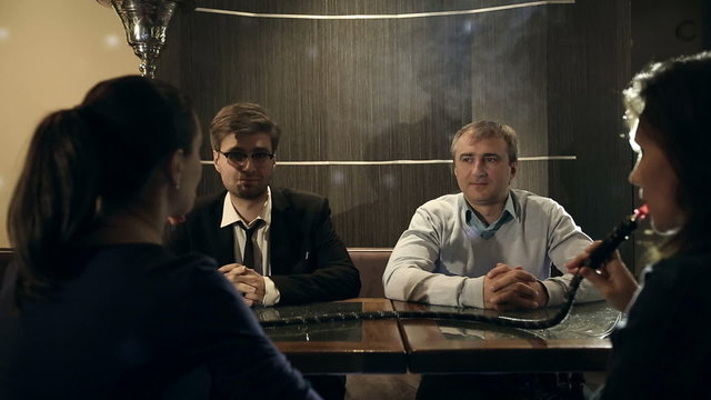 Company people enjoy hookah and communication.