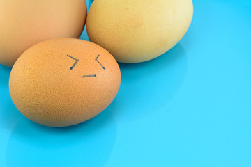 eggs with face  on blue plate for food concept