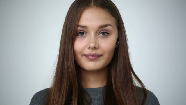 Young girl with braces on teeth looking at camera and smiling.