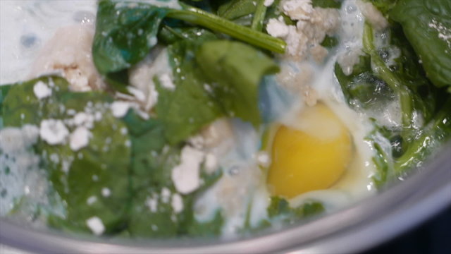 Cooking fresh spinach with egg in a steel pot