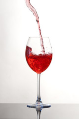 Vino che viene versato in un calice, sfondo bianco