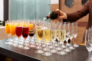 Gordijnen Bartender is pouring sparkling wine in glasses © Kondor83