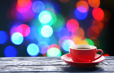 Cup of hot drink on bright background