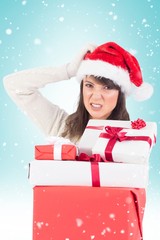 Attractive santa woman scratching head and holding gifts