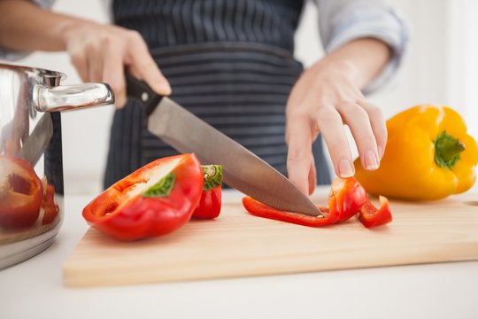 Woman slicing up red pepper