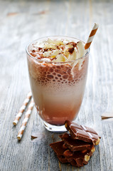Chocolate beverage in glass with whipped cream on wooden backgro