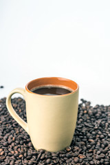 Orange cup of coffee on a background coffee beans