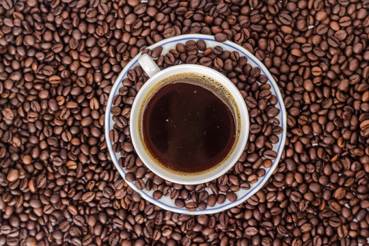 mug of black coffee on background of coffee bean