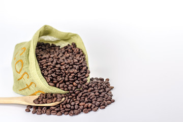 wooden spoon on a background of green bag full of coffee beans