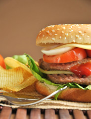 hamburger with cheese, tomato, onion and lettuce