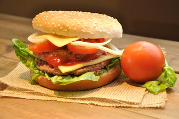 hamburger with cheese, tomato, onion and lettuce