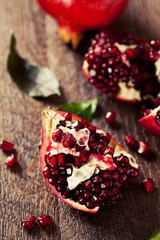 Open fresh ripe pomegranates on wooden background