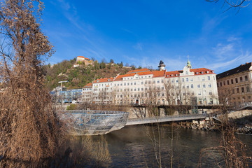Island on Mur river connected by a modern steel and glass bridge