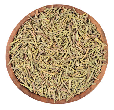 Dried rosemary in a wooden bowl on a white