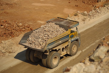 huge trucks work in a quarry mining